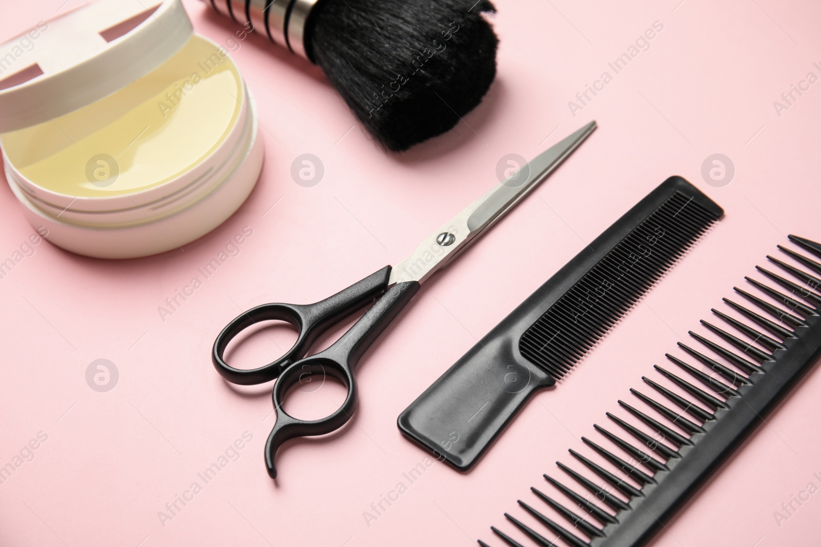 Photo of Professional hairstyling tools on light pink background