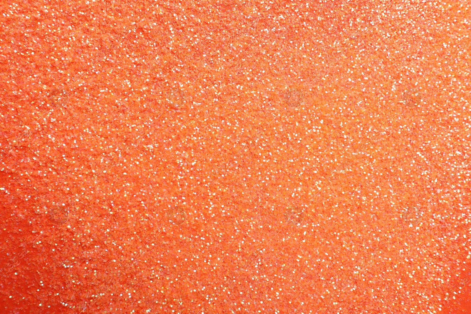 Photo of Shiny bright glitter on coral background, flat lay