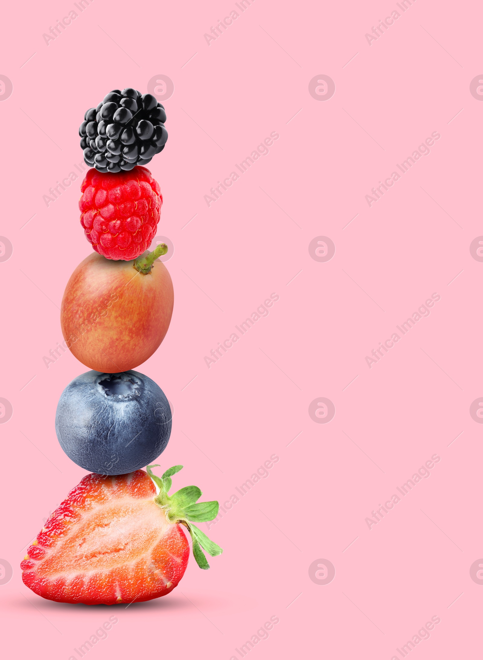 Image of Stack of different fresh tasty berries on pink background, space for text