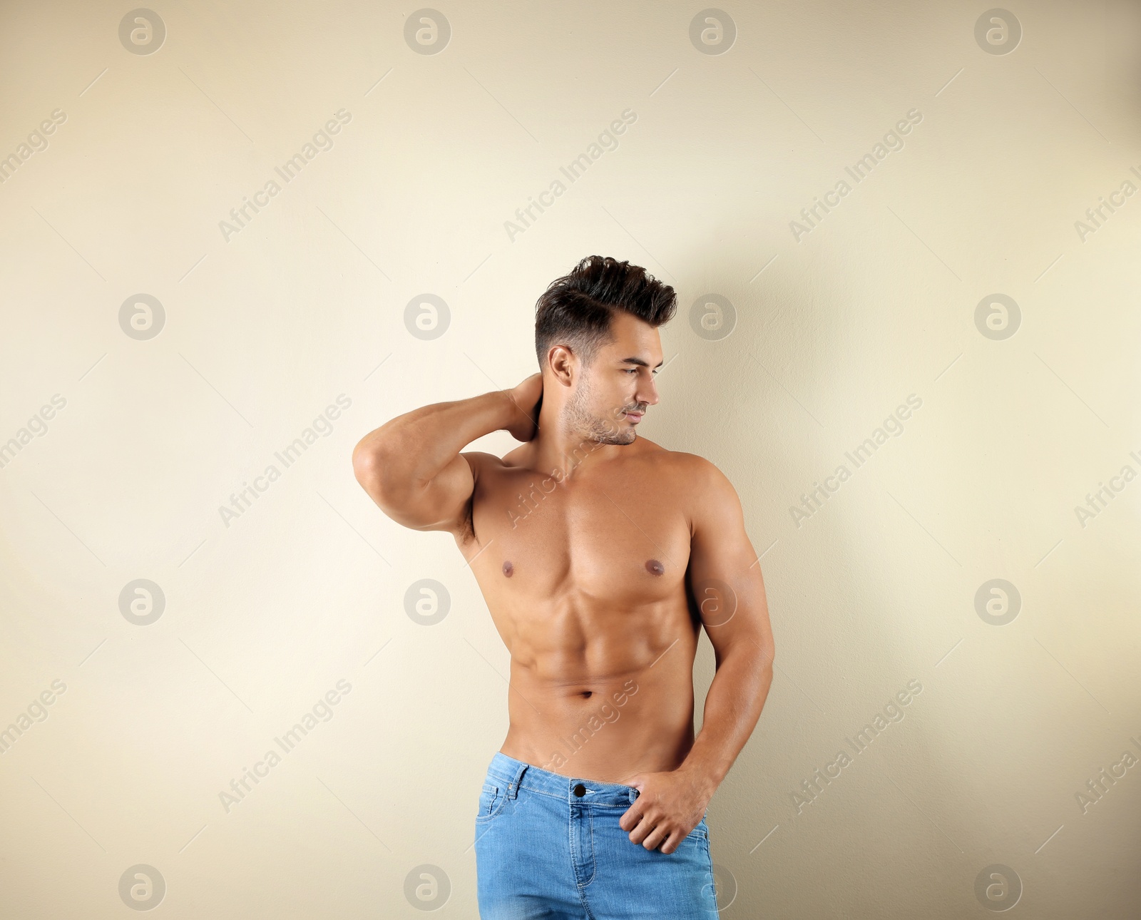 Photo of Shirtless young man in stylish jeans on light background