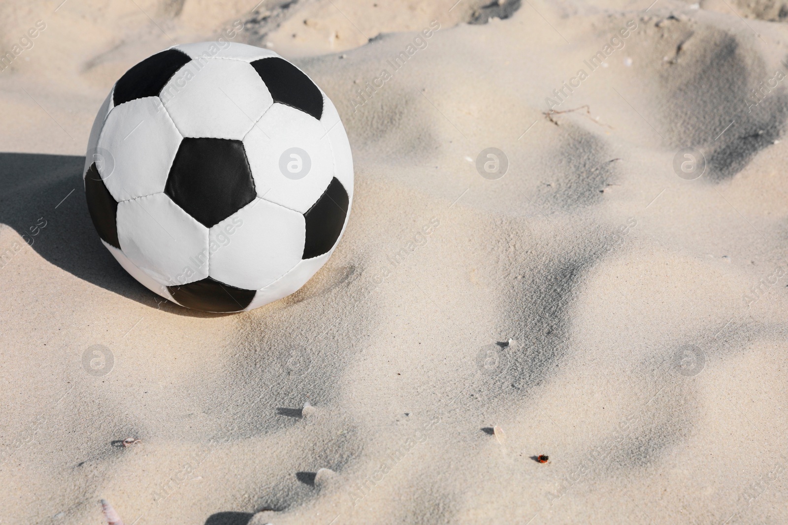 Photo of Soccer ball on sand, space for text. Football equipment