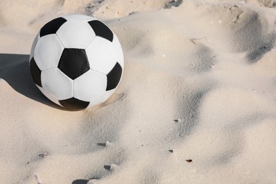 Photo of Soccer ball on sand, space for text. Football equipment