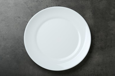 Photo of Empty white ceramic plate on grey table, top view