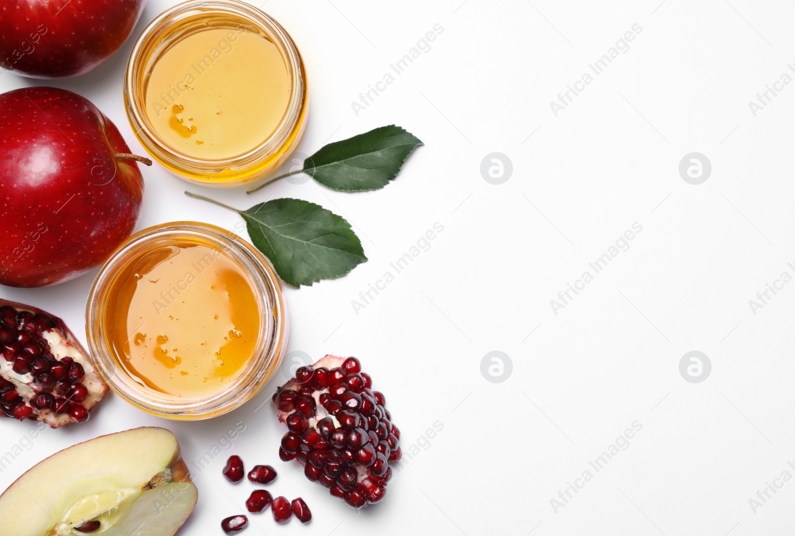 Photo of Honey, apples and pomegranate on white background, flat lay. Rosh Hashanah holiday