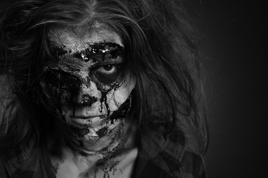 Photo of Scary zombie on dark background, black and white effect. Halloween monster