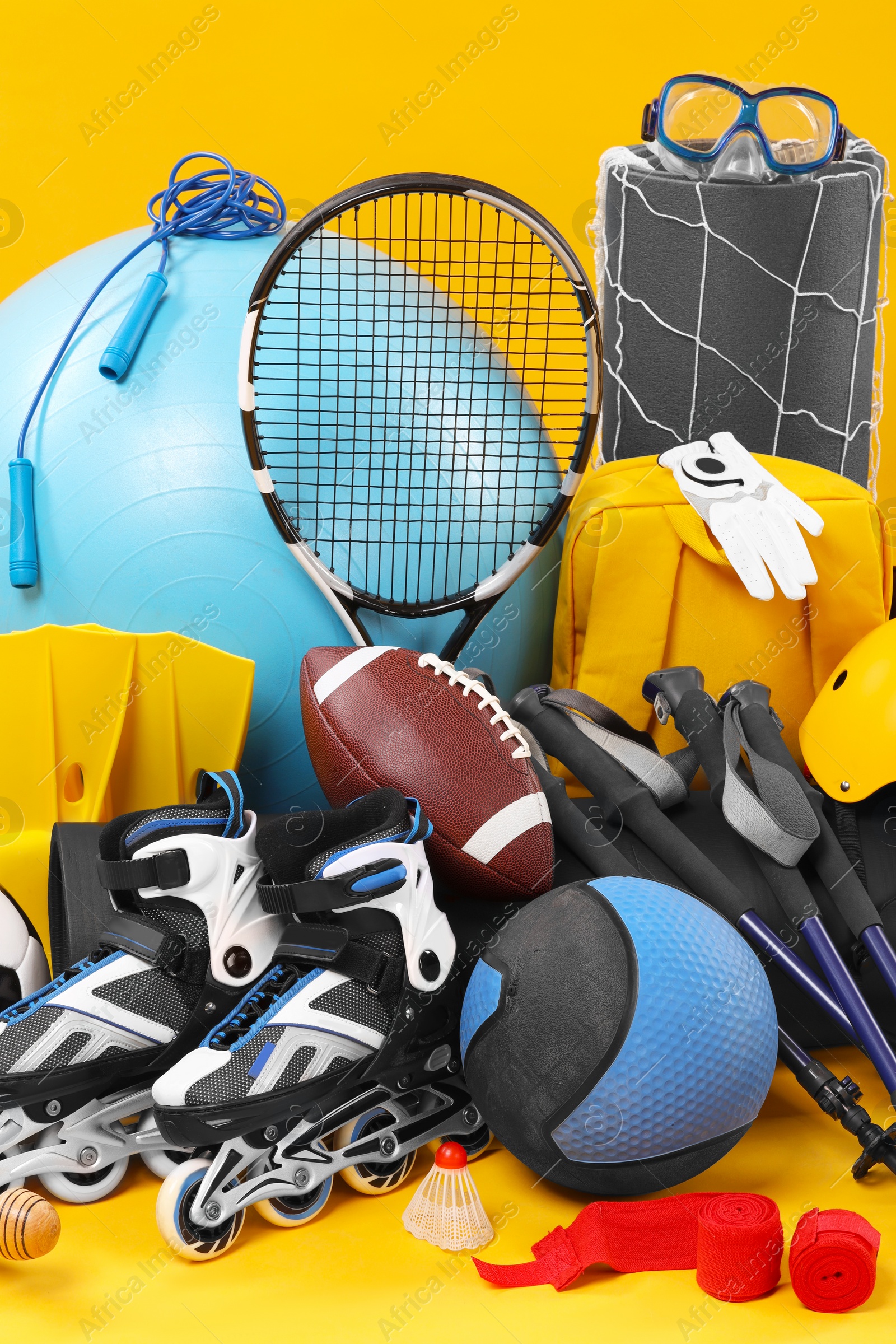 Photo of Many different sports equipment on yellow background