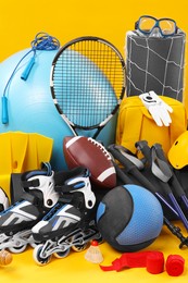 Many different sports equipment on yellow background