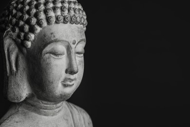 Photo of Beautiful stone Buddha sculpture on black background, closeup. Space for text