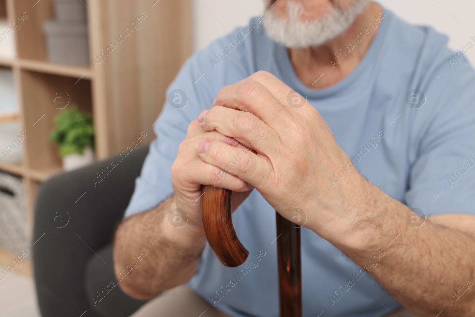 Photo of Senior man with walking cane at home, closeup