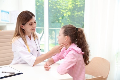 Doctor checking little girl's pulse in hospital