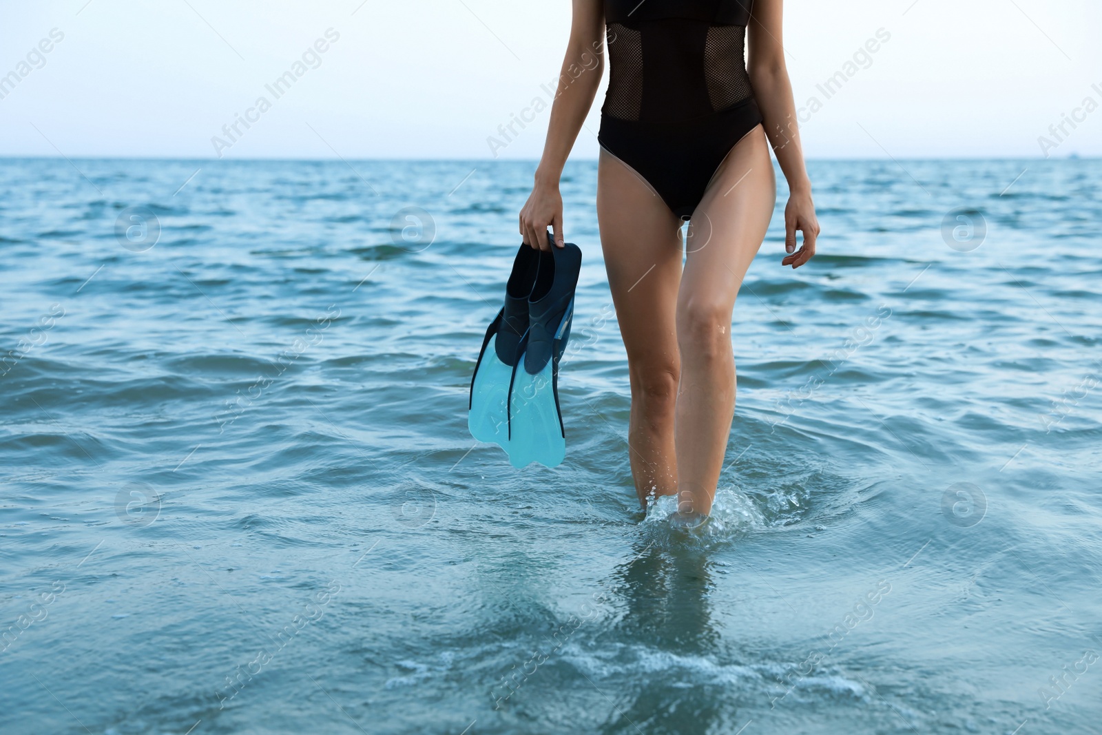 Photo of Woman with flippers walking out of sea water, closeup