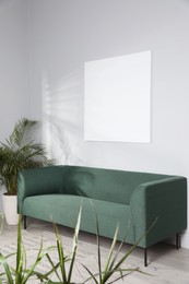 Photo of Living room interior with green sofa and blank canvas. Space for design