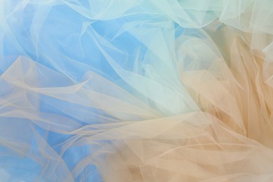 Photo of Beautiful colorful tulle fabrics as background, closeup