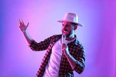 Emotional man with microphone singing in neon lights