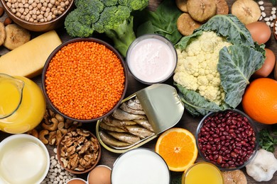 Photo of Set of natural food high in calcium on wooden table, flat lay