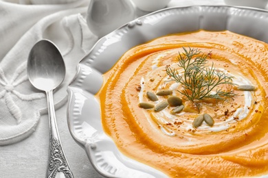 Photo of Plate with tasty pumpkin soup on table, closeup