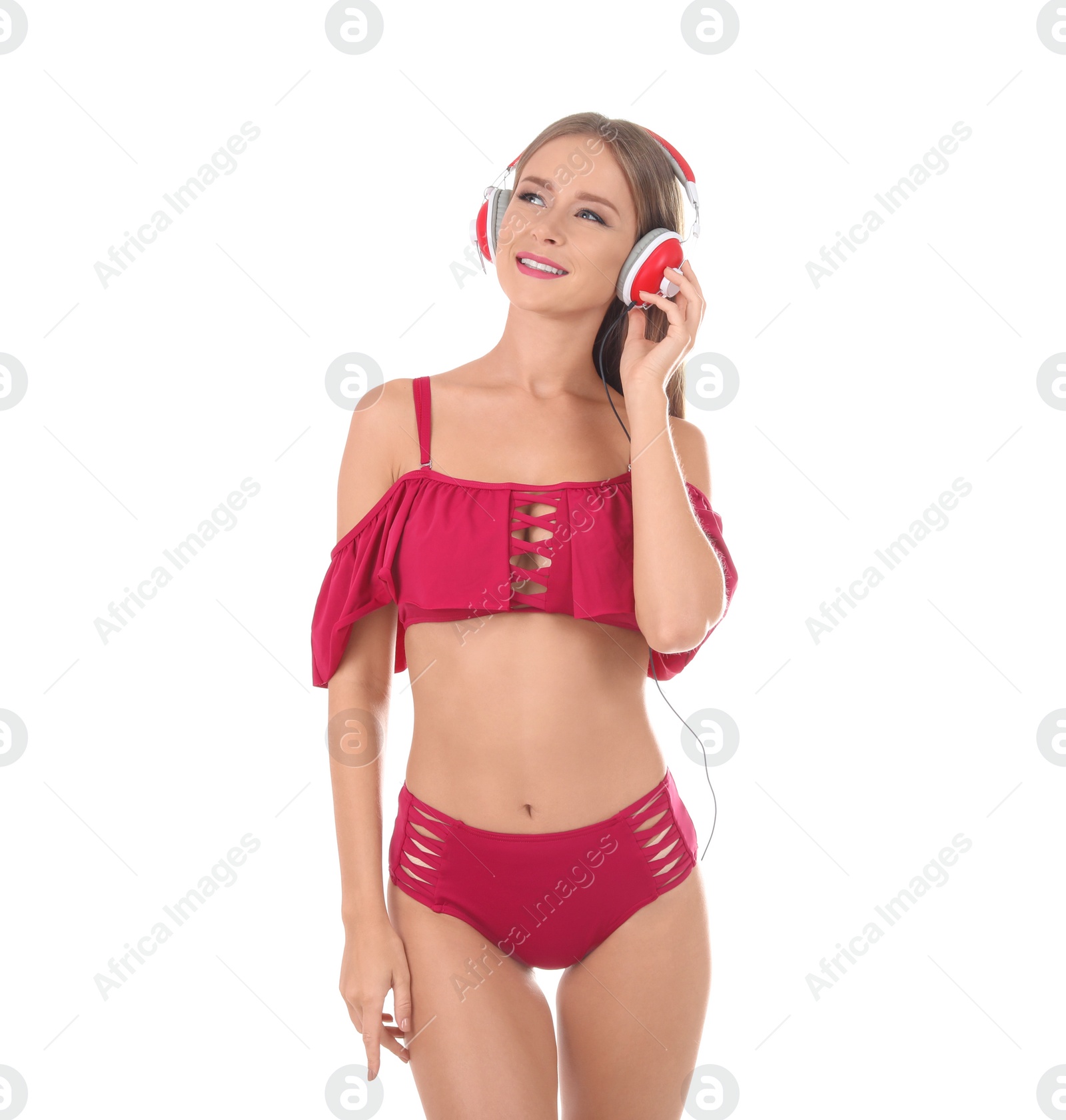 Photo of Sexy young woman in bikini listening to music on white background