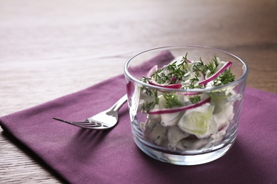 Delicious fresh cucumber onion salad with dressing in bowl served on table, space for text