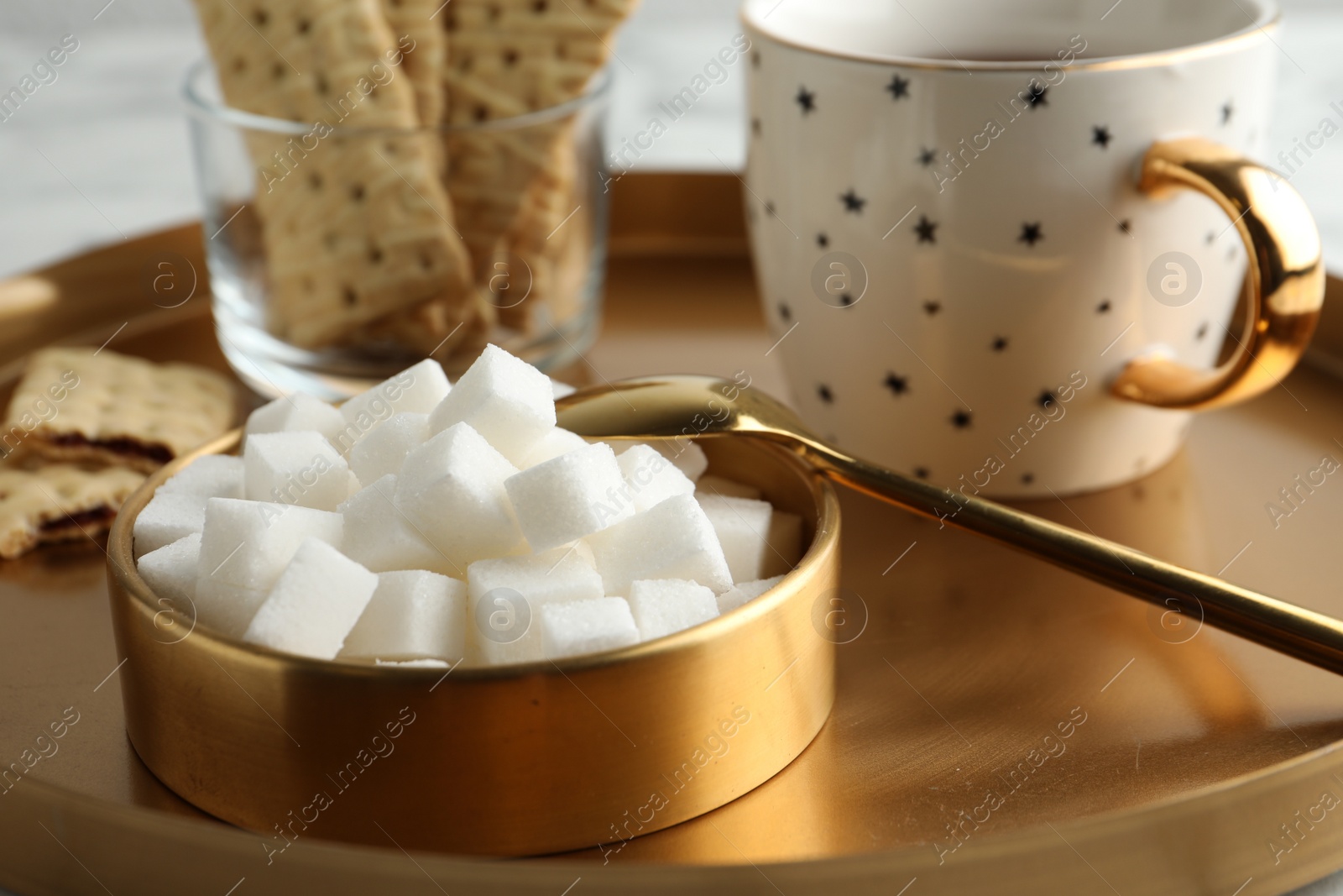Photo of Refined sugar cubes in bowl on table, closeup