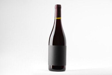 Photo of Bottle of tasty red wine on white background, space for text