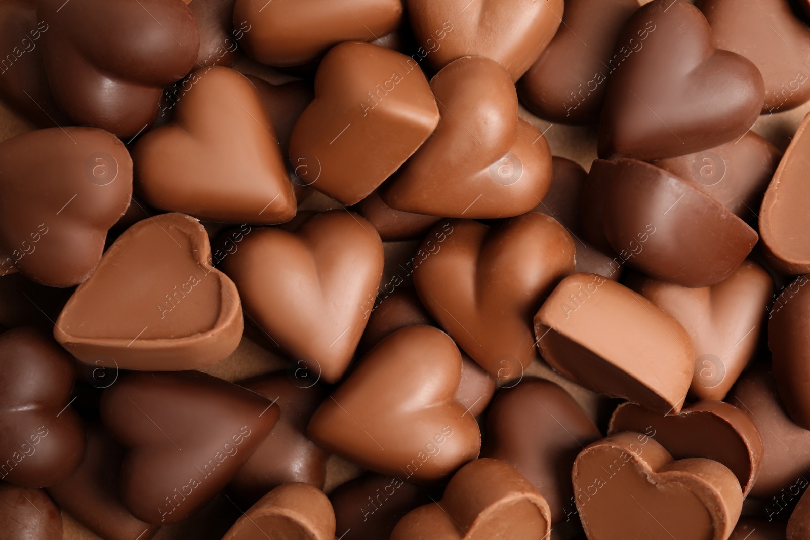 Photo of Tasty heart shaped chocolate candies as background, top view. Valentine's day celebration