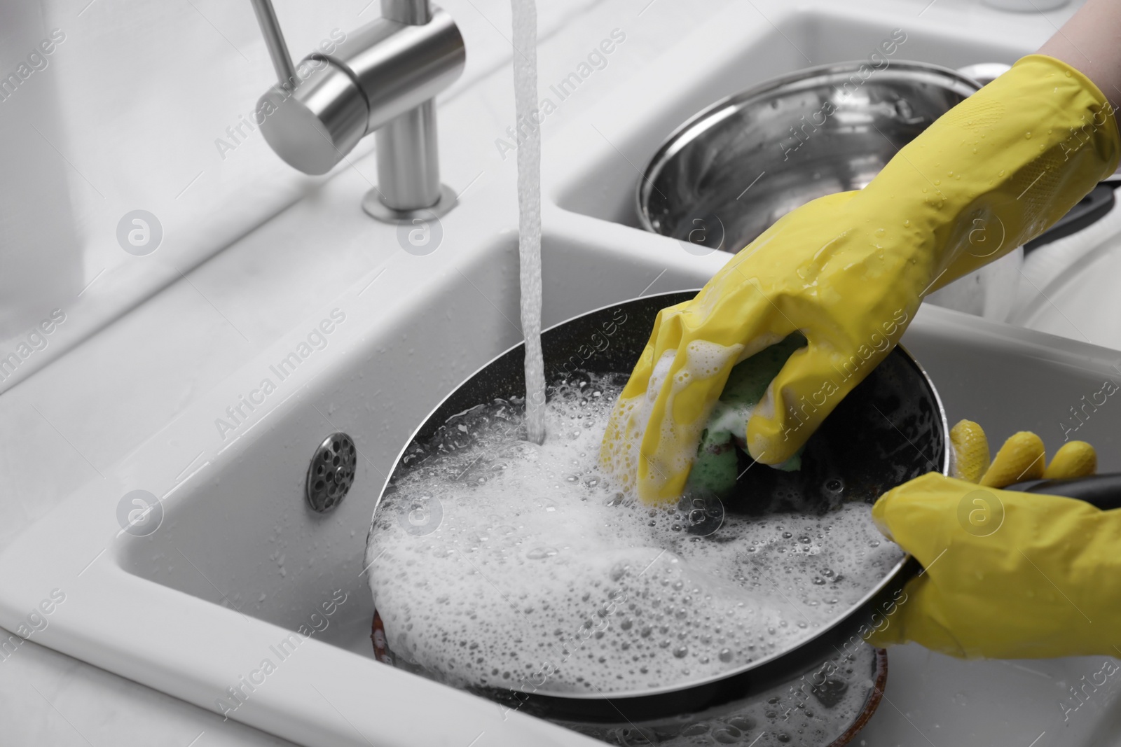 Photo of Woman washing dirty dishes in kitchen sink, closeup