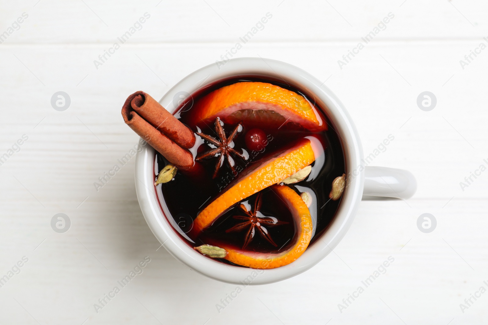 Photo of Aromatic mulled wine on white wooden table, top view