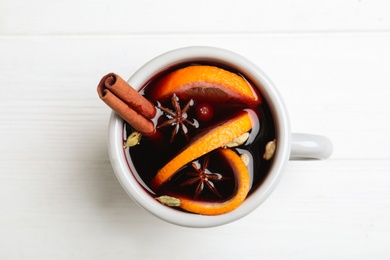 Photo of Aromatic mulled wine on white wooden table, top view