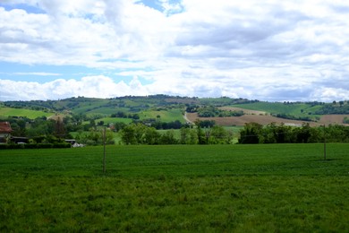 Photo of Beautiful landscape with green pasture on hill under blue sky