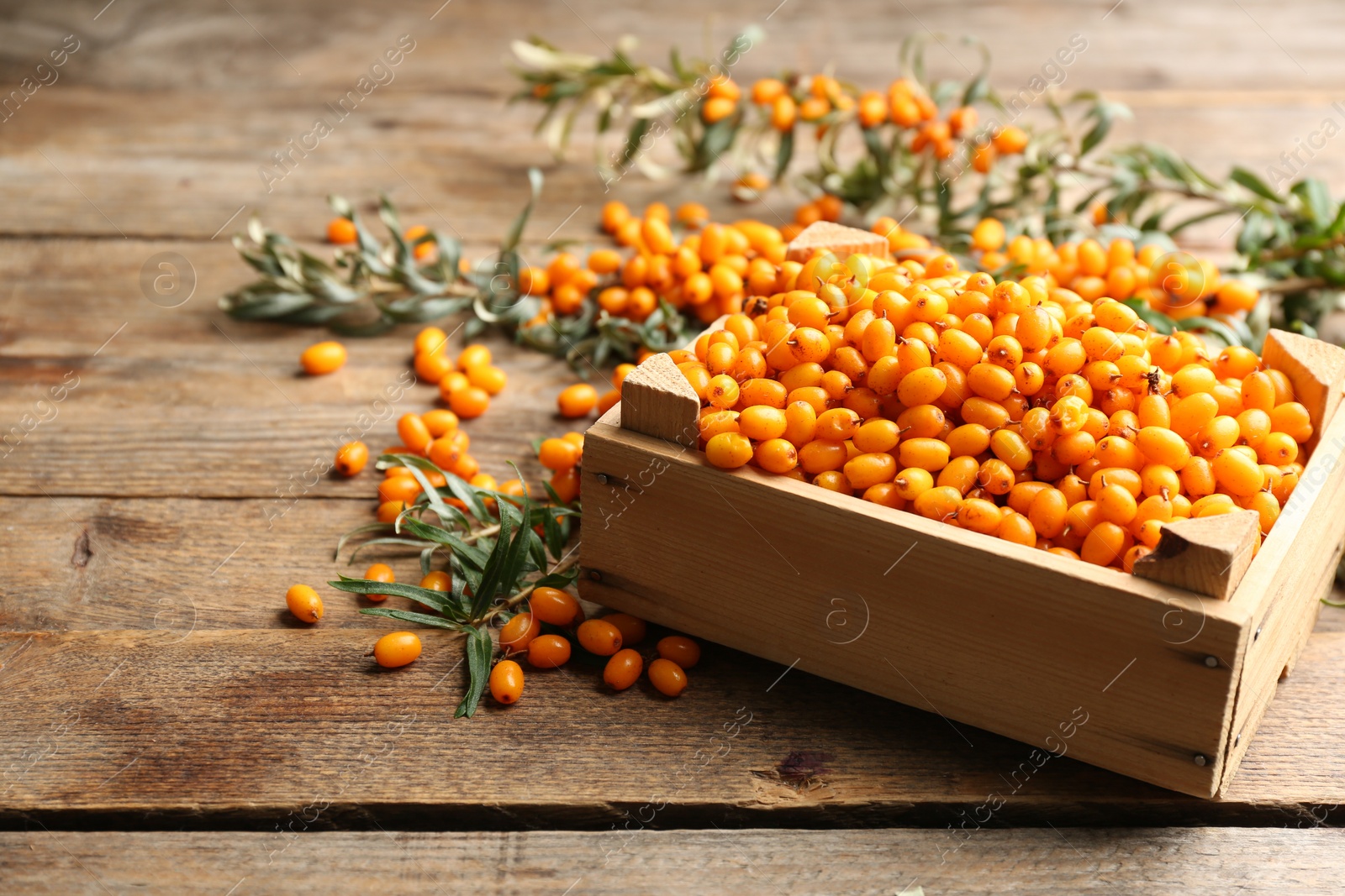 Photo of Ripe sea buckthorn berries on wooden table