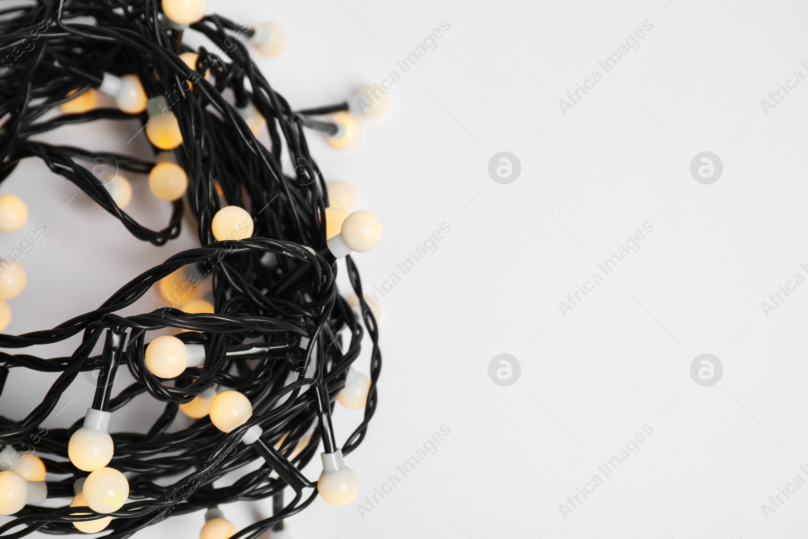 Photo of Beautiful Christmas lights on white background, top view