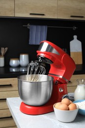 Modern stand mixer and ingredients on table in kitchen. Home appliance