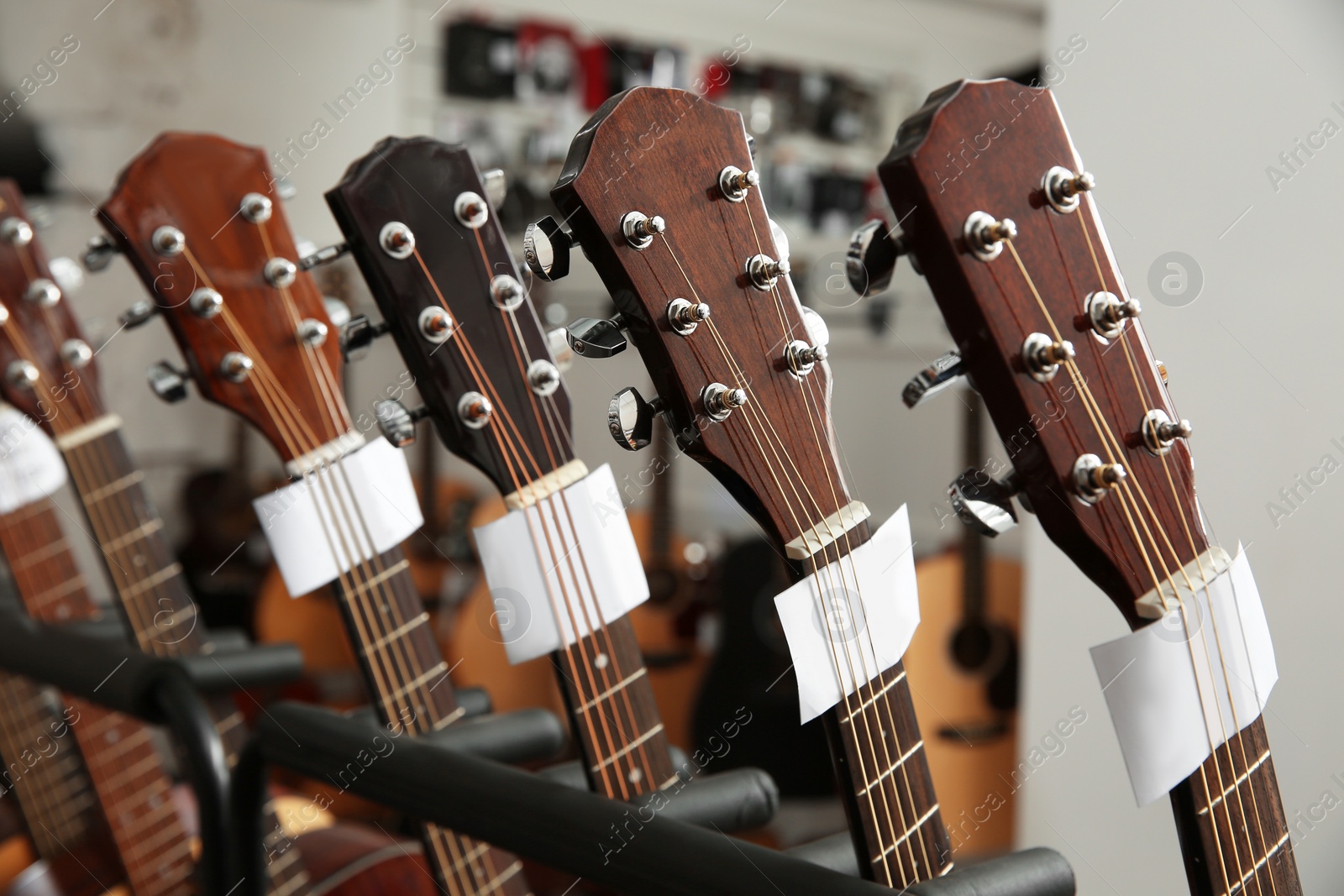 Photo of Row of different guitars in music store, closeup