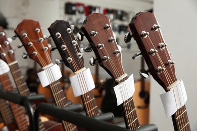 Photo of Row of different guitars in music store, closeup