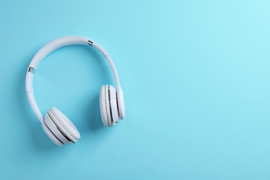 Wireless headphones on color background, top view. Space for text