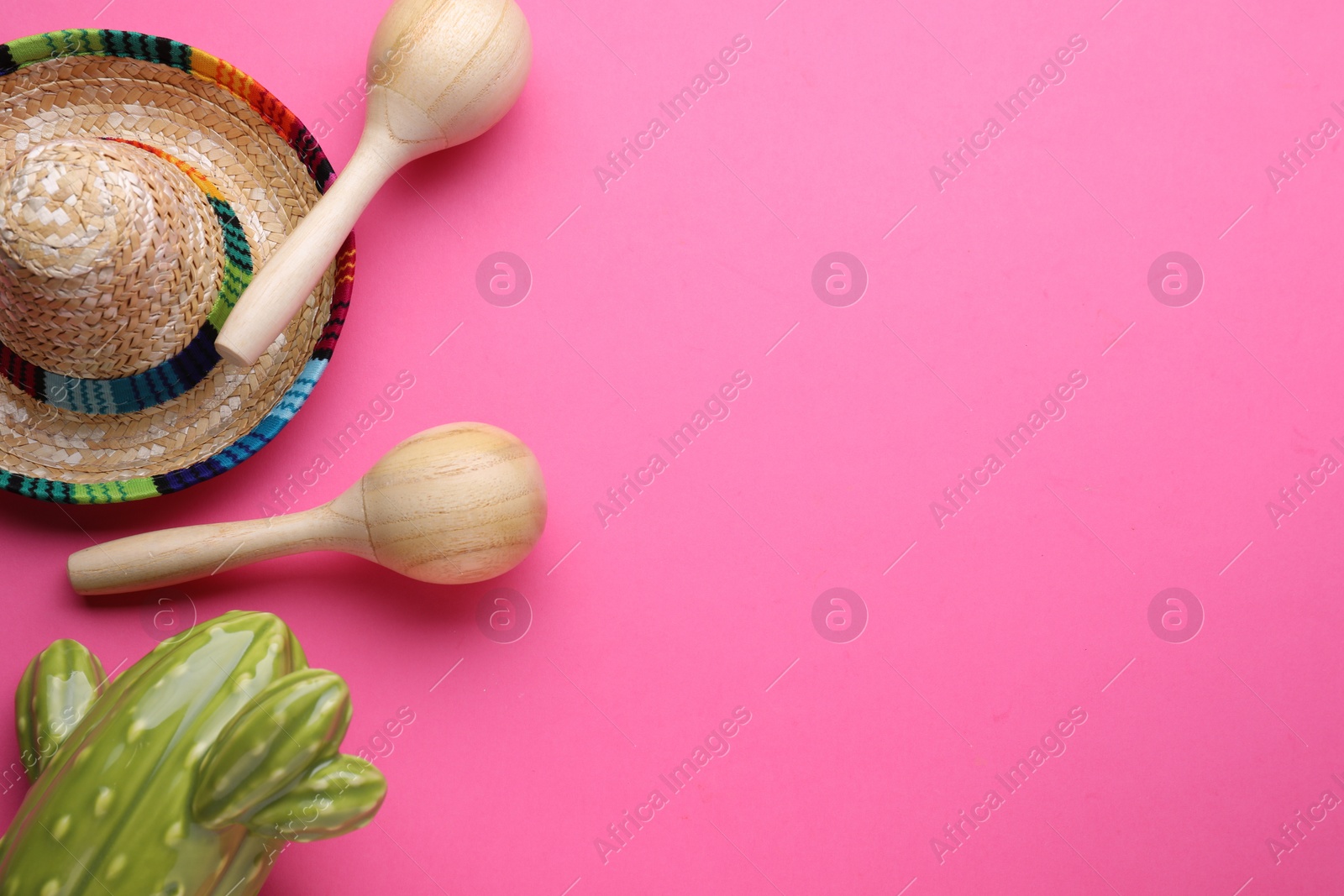 Photo of Wooden maracas, toy cactus and sombrero hat on pink background, flat lay with space for text. Musical instrument