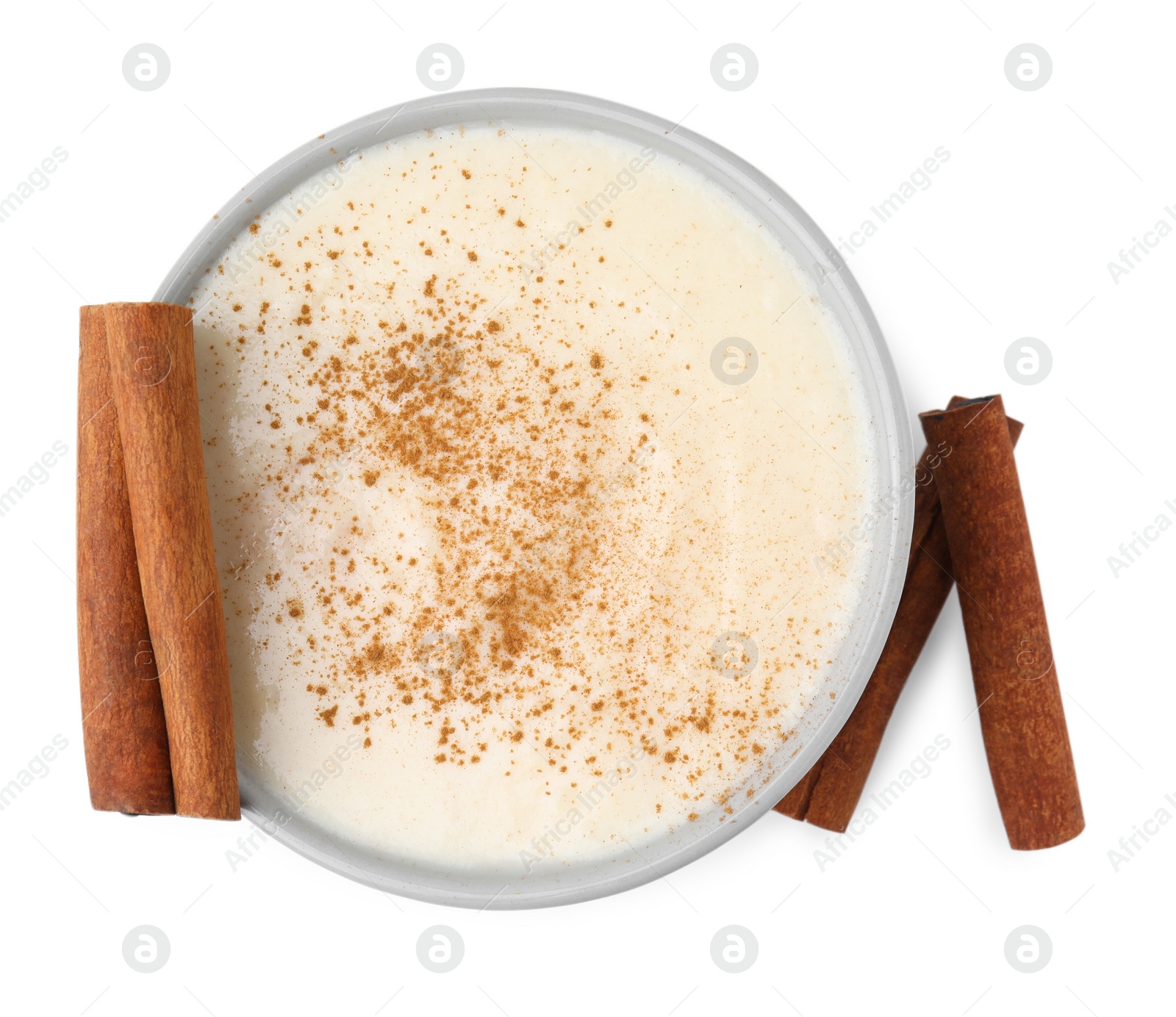 Photo of Delicious semolina pudding with cinnamon in bowl isolated on white, top view