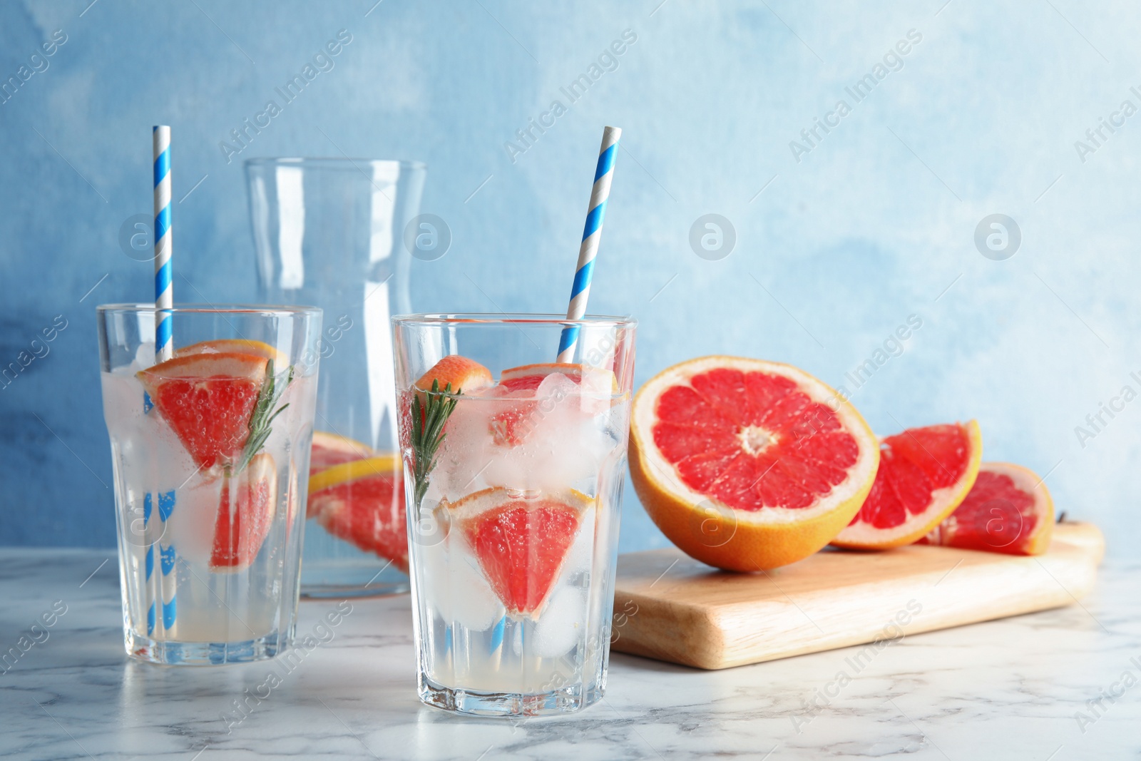 Photo of Glasses of infused water with grapefruit slices on table. Space for text