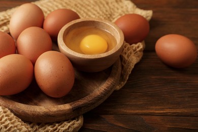Photo of Raw chicken eggs on wooden table, closeup