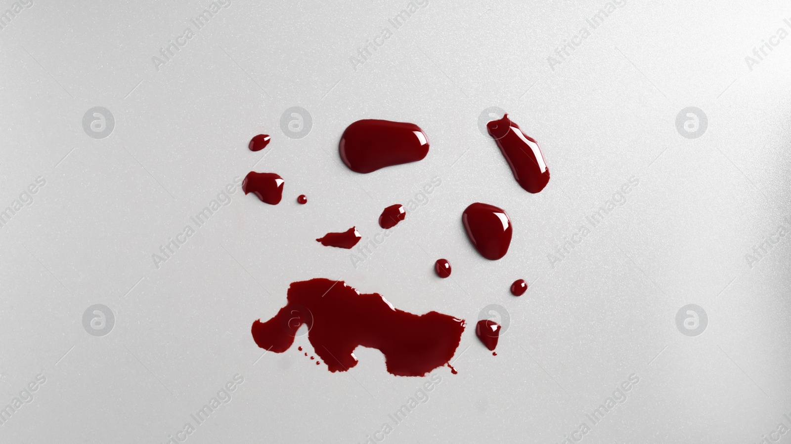 Photo of Drops of blood on grey background, top view