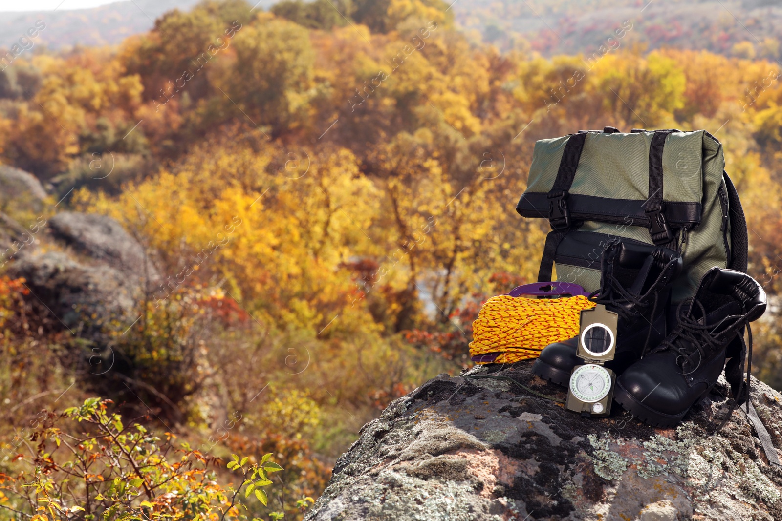 Photo of Set of camping equipment on rock outdoors. Space for text