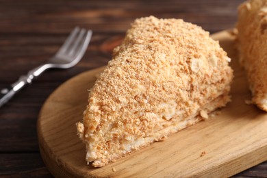 Piece of delicious Napoleon cake served on table, closeup