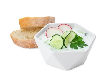 Delicious cold summer soup and bread on white background