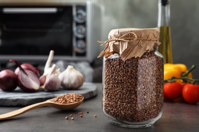 Photo of Buckwheat grains on grey table against blurred background. Space for text