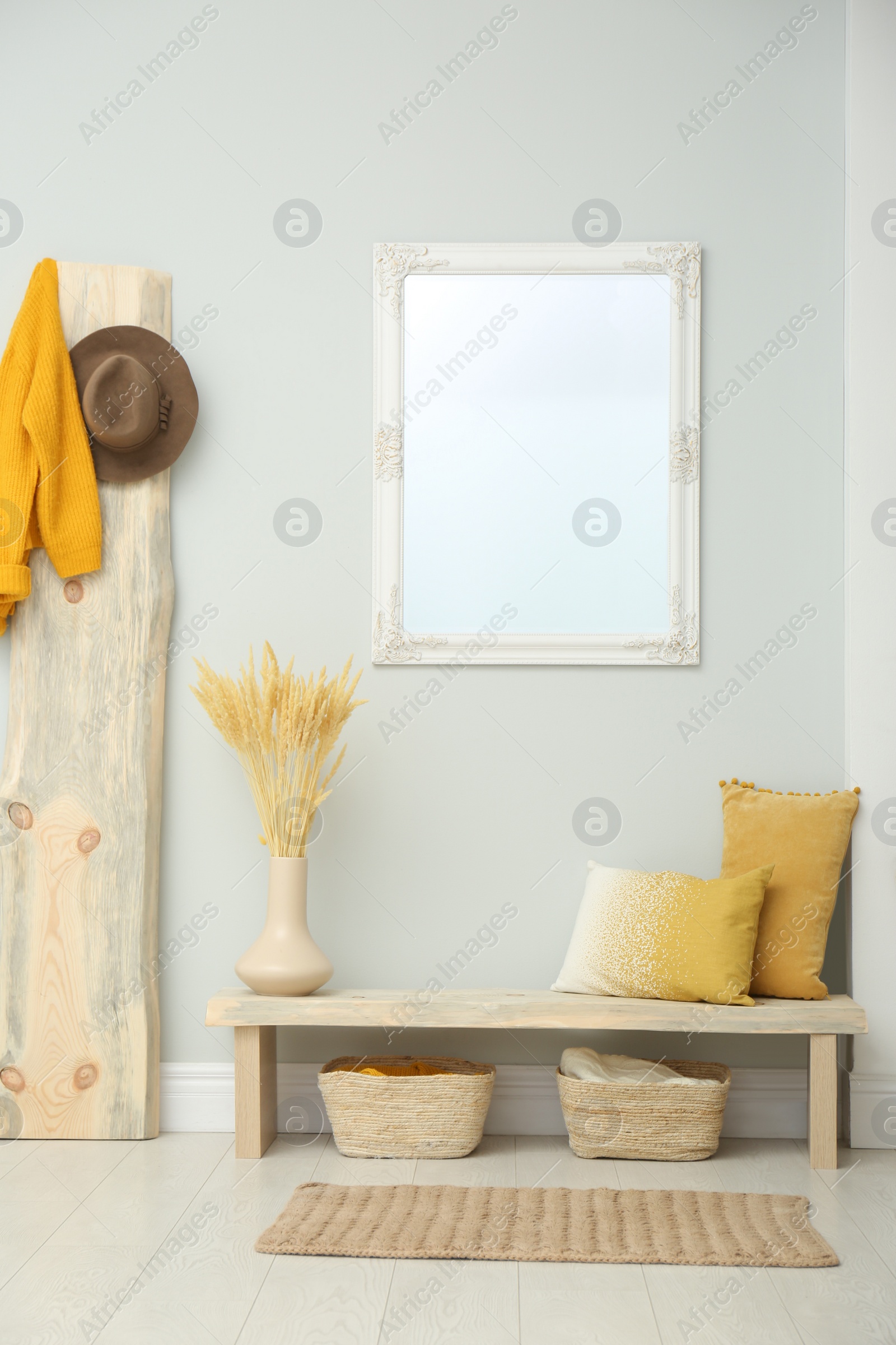 Photo of Hallway interior with wooden bench, clothes and mirror