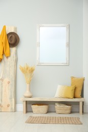 Hallway interior with wooden bench, clothes and mirror