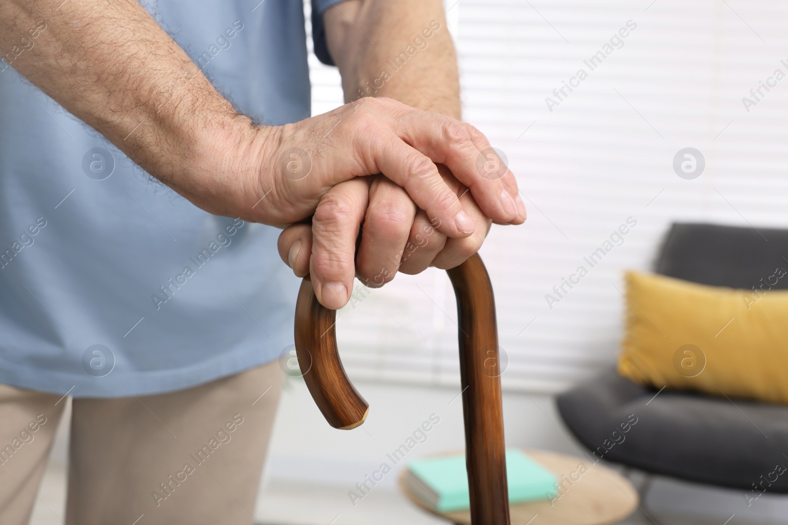 Photo of Senior man with walking cane at home, closeup