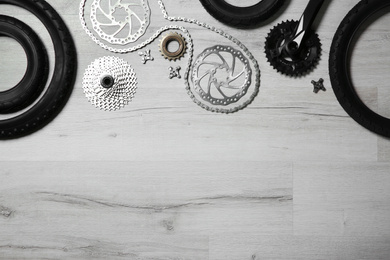 Photo of Set of different bicycle parts on wooden background, flat lay. Space for text