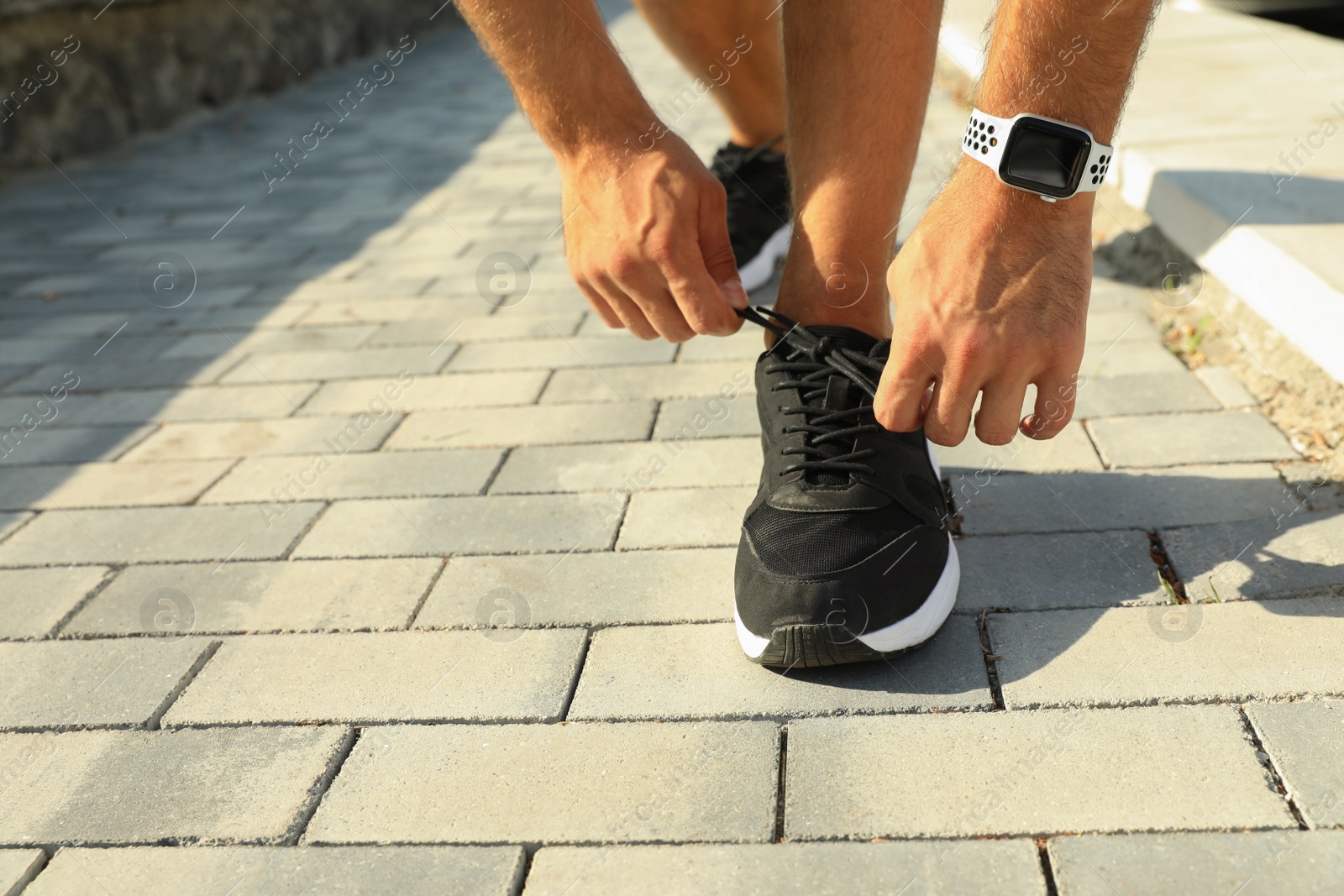 Photo of Woman wearing modern smart watch during training outdoors, closeup