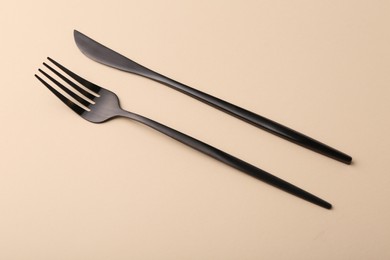Photo of Stylish cutlery on beige table, above view